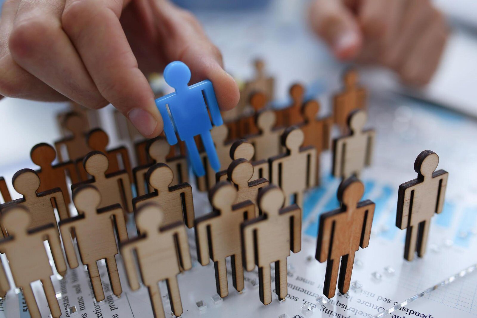 A hand selecting one candidate figure from among many